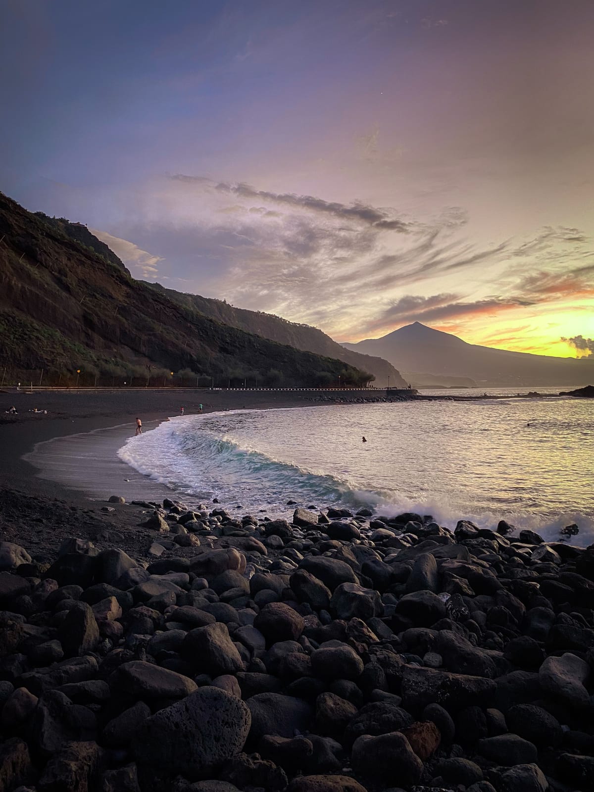 Svart steinstrand på Tenerife i solnedgang